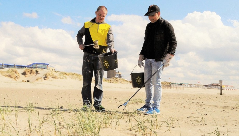 twee mannen samen bezig met het schoonhouden van een buitengebied