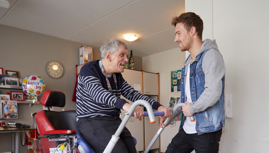 Twee personen waarvan één op een rollator