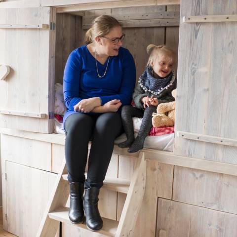 Vrouw en kind op de rand van een bedstee