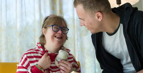 Begeleider leest boekje voor aan vrouw