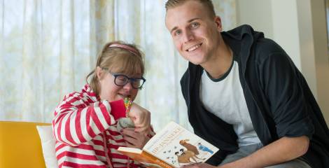 Vrouw wijst iets aan in bokje aan begeleider