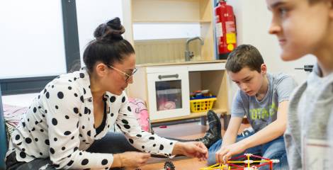 Vrouw zit op de grond en speelt een spel met jongen 